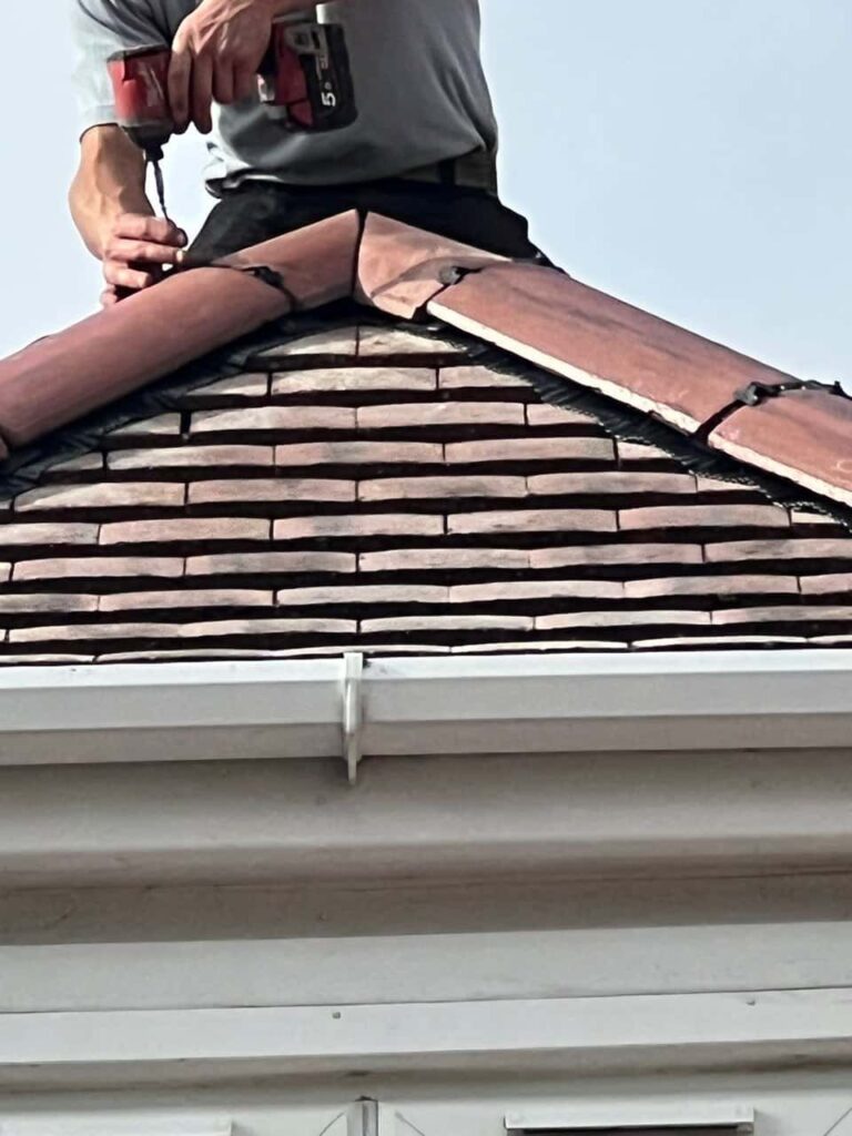 This is a photo of one of the operatives of Alfreton Roofing Repairs installing new ridge tiles